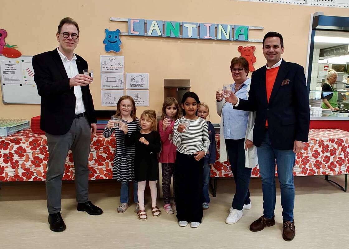 Foto (Trauner) – v. l.: Freuen sich gemeinsam mit den Kindern über den Wasserspender: Rektor Markus Istenes, OGTS-Leiterin Gabriele Saleh-Ziabari und Bürgermeister Emanuel Staffler.  
